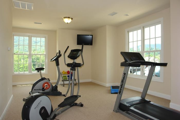 The clubhouse fitness room with cardio equipment and mountain views
