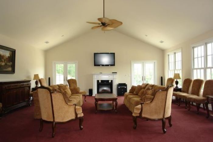 The clubhouse great room with sofas, a fireplace, and vaulted ceiling