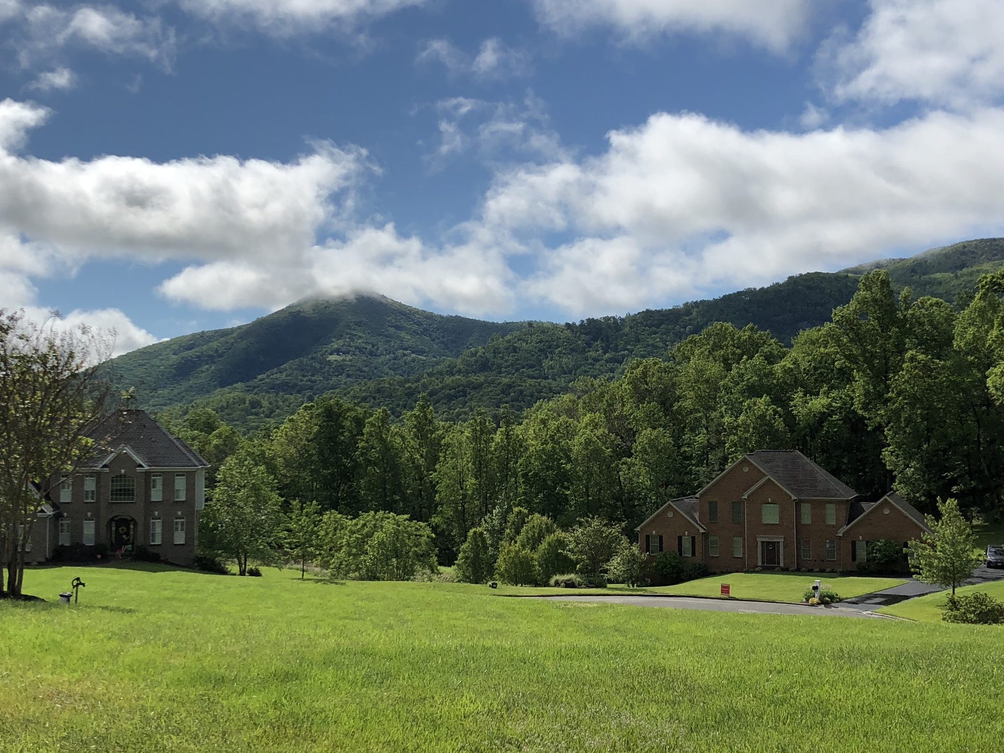Homes in Old Mill Plantation set against the green Blue Ridge Mountains under a bright sky